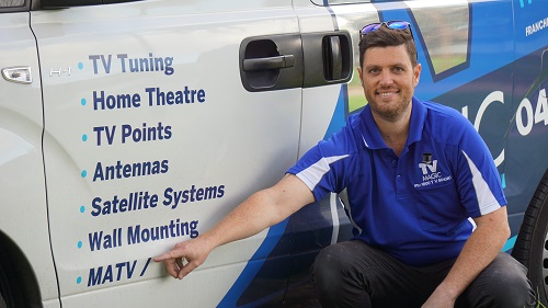 a technician pointing to MaTV services on the side of his van