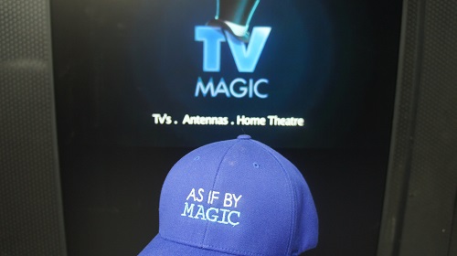 A TV screen with TV Magic logo on screen and a hat which says "As If By Magic"