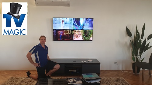 Brent in front of a TV he installed. TV Magic logo in top left corner