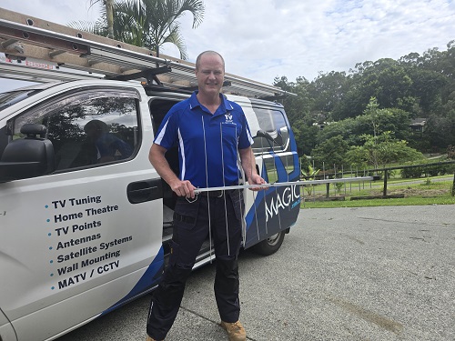 Technician holding an antenna near his van