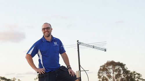 Technician standing next to an antenna installation