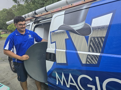 Technician getting a satellite dish out of his van.