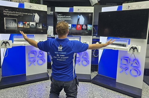 Technician in front of a lot of gaming consoles for a commercial setup