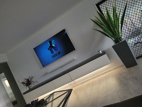 Samsung Frame TV wall mounted in a living room with a sound bar beneath it