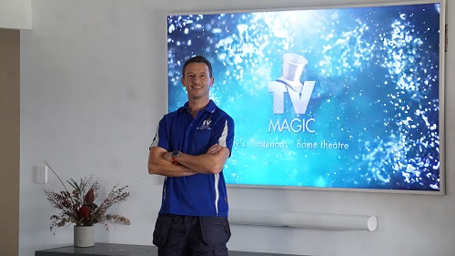 Technician Jim in front of a large TV