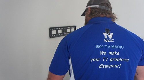 technician attending to TV wall mounting job