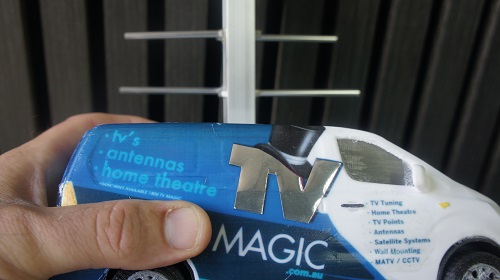 Technician holding mini TV Magic van in front of an antenna