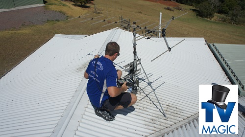 a technician on the roof of a house fixing an antenna
