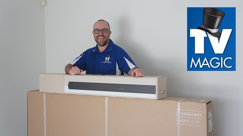 technician with a brand new TV and sound bar. TV Magic logo in top right corner