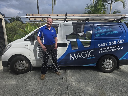 Technician Ben holding an antenna next to his van.