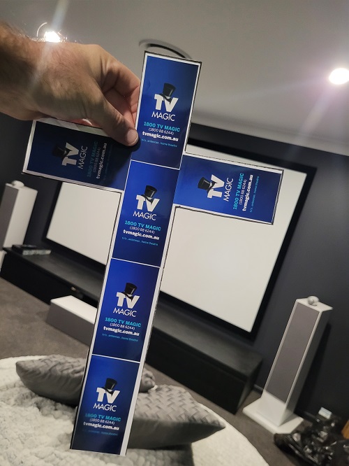 Technician holding up a cross in front of a TV