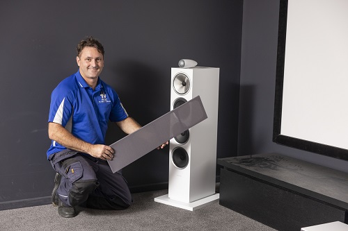 Technician with a large speaker in home theatre