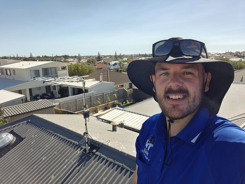 Technician on a roof post antenna installation