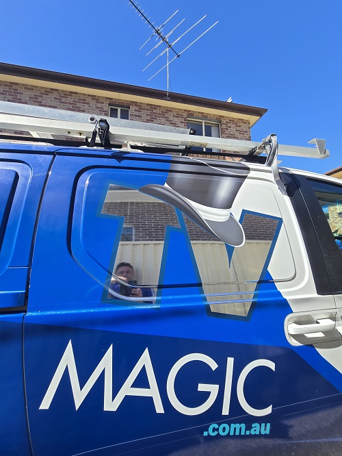 Side of TV Magic van below an antenna installation.